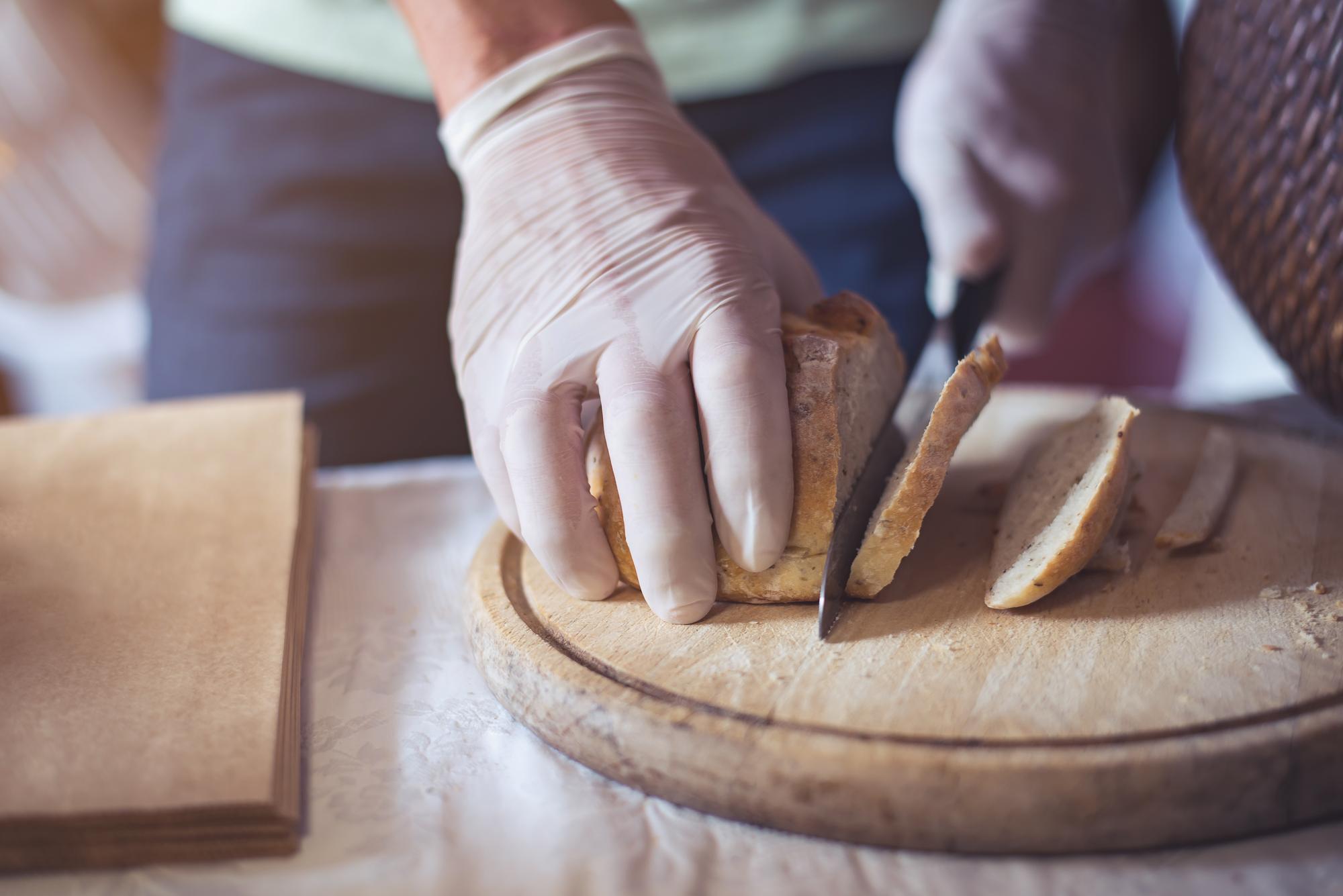Hands shaping dough on a wooden board
